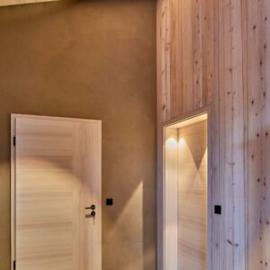 Lebhafte Beleuchtung von Holztüren im Flur eines Einfamilienhauses